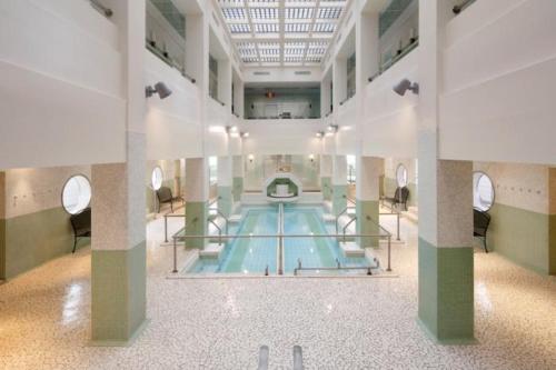 une grande piscine dans un grand bâtiment dans l'établissement Spacieux duplex tout confort à 200m des thermes de Bains-les-Bains dans les Vosges, à Bains-les-Bains
