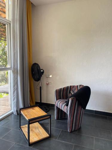 a living room with a chair and a table at Eagle View Lodge - Kigali in Kigali