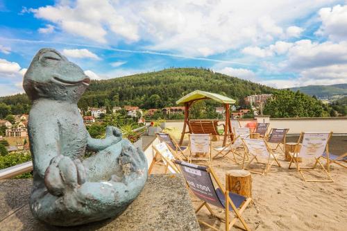 eine Statue eines Frosches auf einem Felsvorsprung mit Stühlen in der Unterkunft Schwarzwald Panorama in Bad Herrenalb