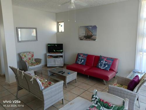 a living room with a red couch and chairs at Ankers in Margate