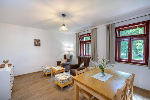a living room with a wooden table and chairs at Apartmány Pernek in Horní Planá
