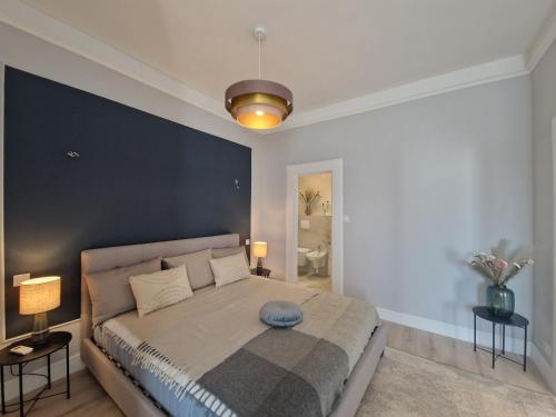 a bedroom with a large bed with a blue wall at Danube Wonder View 2 in Budapest