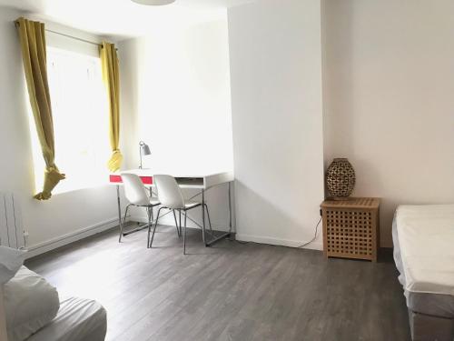 - une chambre avec une table, des chaises et une fenêtre dans l'établissement Triplex à 100m de la plage, à Dieppe