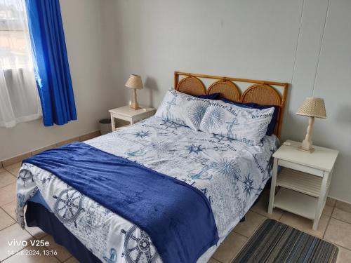 a bedroom with a blue and white bed with two night stands at Ankers in Margate