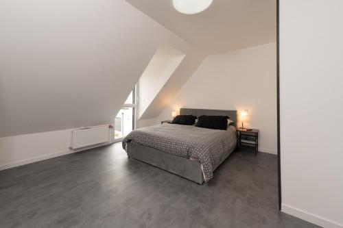 a white bedroom with a bed and a mirror at Ma Bro - ERDIVINES in Erdeven