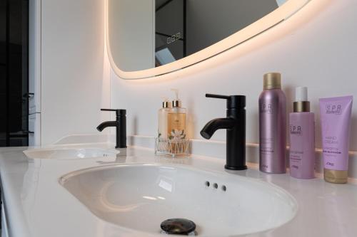 a bathroom sink with a mirror and cosmetics on it at Ma Bro - ERDIVINES in Erdeven