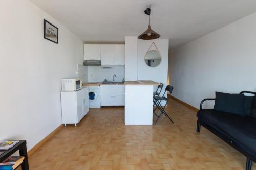 un salon avec un canapé et une cuisine dans l'établissement appartement avec vue sur la mer, au Grau-dʼAgde