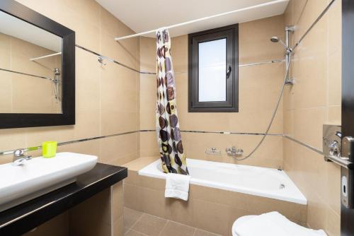 a bathroom with a sink and a tub and a window at Villa Dias in Lachania