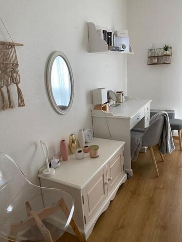 Cette chambre blanche dispose d'une table et d'un miroir. dans l'établissement Maison pavillonnaire entre océan et montagnes basques, à Cambo-les-Bains