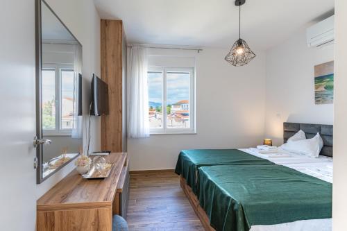 a bedroom with a bed and a table and windows at 4 GENTLEMEN VILLAS with private jacuzzi in Novalja