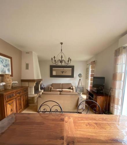 - un salon avec un canapé et un lustre dans l'établissement Maison pavillonnaire entre océan et montagnes basques, à Cambo-les-Bains