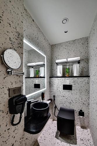 a bathroom with a sink and a mirror at Quality Inn City Centre Varanasi in Varanasi