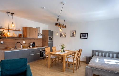 a kitchen and dining room with a table and chairs at Apartmány Pernek in Horní Planá