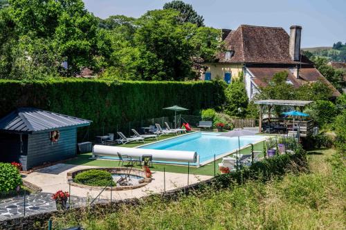 une piscine dans une cour avec une maison dans l'établissement Logis Auberge du Relais - Hôtel & Restaurant, à Berenx