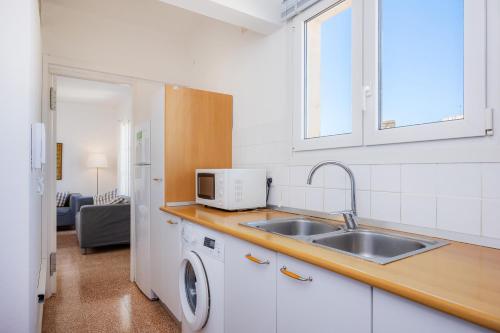 a kitchen with a sink and a microwave at Can Manuel in Felanitx