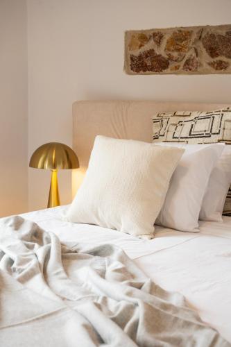 a white bed with white sheets and pillows at Majestic Villa overlooking Acropolis with Hot Tub in Athens