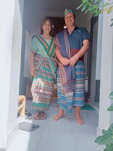 a man and a woman standing on a porch at Stay Together in Tetebatu