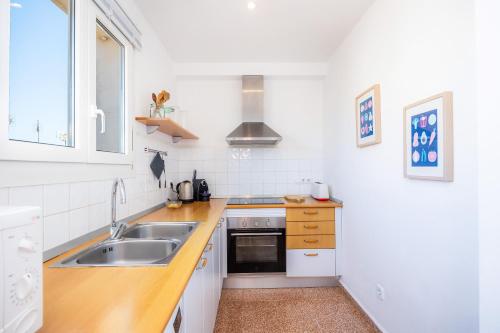 a white kitchen with a sink and a stove at Can Manuel in Felanitx