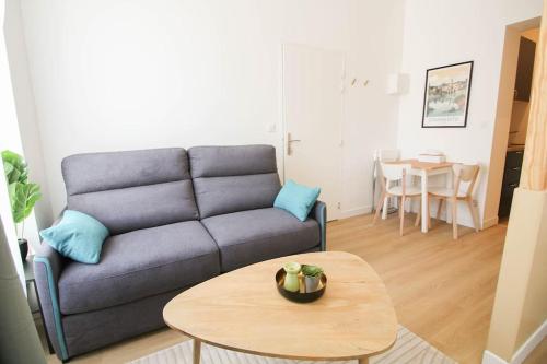 un salon avec un canapé et une table dans l'établissement G1 Appartement Familial lumineux RDC centre Angouleme, à Angoulême