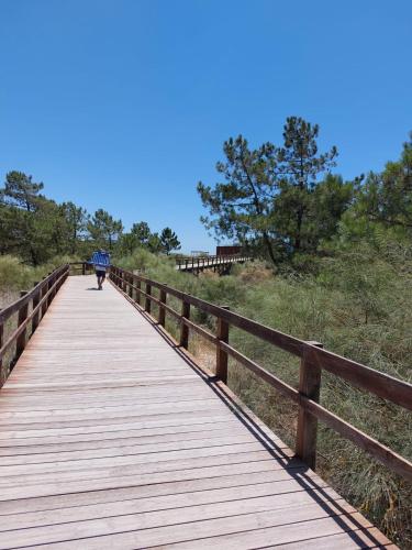 a person walking on a wooden bridge with an umbrella at Blue Dragon River House in Odeleite