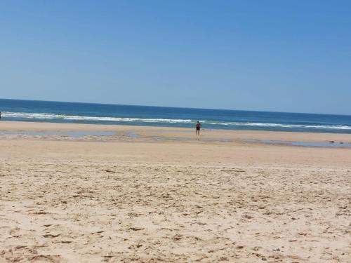 a person standing on a beach near the ocean at Blue Dragon River House in Odeleite