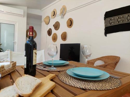 a table with a bottle of wine and bread on it at Blue Dragon River House in Odeleite