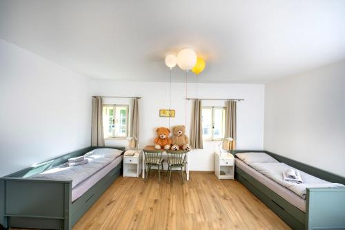 a bedroom with two beds and a table with teddy bears at Apartmány Pernek in Horní Planá