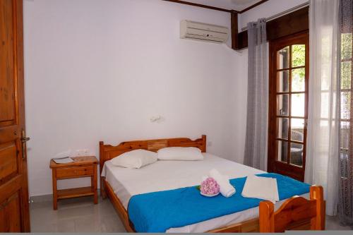 a bedroom with a bed and a window at Paradeisos Rooms Pelion in Agios Dimitrios