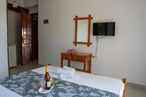 a room with a table with a bottle of wine on it at Paradeisos Rooms Pelion in Agios Dimitrios