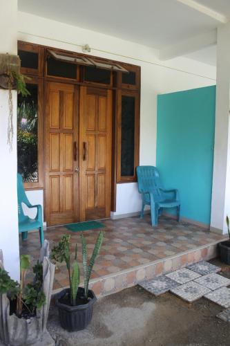 two blue chairs sitting in front of a door at eco trekking lodge, Co Bar & jungle tour's only booking with us ! in Bukit Lawang