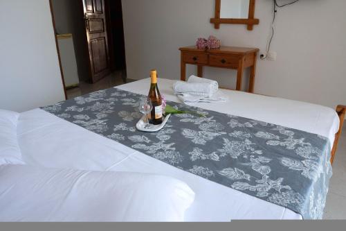 a bottle of wine sitting on top of a bed at Paradeisos Rooms Pelion in Agios Dimitrios