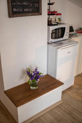 a kitchen with a vase of flowers on a counter at Borea Rooms - Sobe Budanje in Vipava