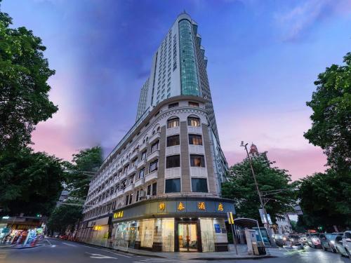 a tall building on the corner of a street at 锦泰酒店--广州市十三行南方大厦国际电子城店 in Guangzhou