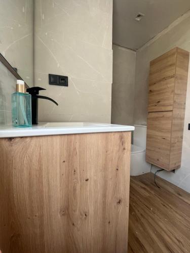 une salle de bains avec un lavabo et un meuble en bois dans l'établissement Las Vistas Faro de Cullera, Valencia, à Faro de Cullera