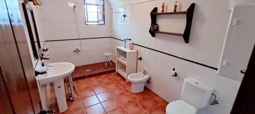 a white bathroom with a toilet and a sink at Casa Rural Cortijo Torres in La Parra