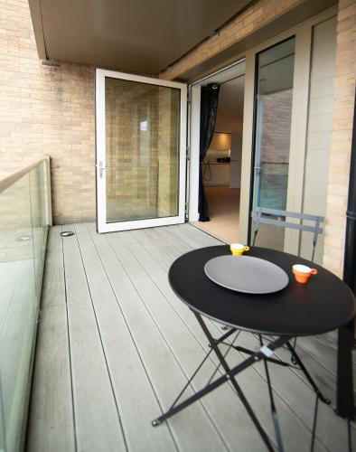 a small black table on the balcony of a house at Heathrow Haven in Yiewsley