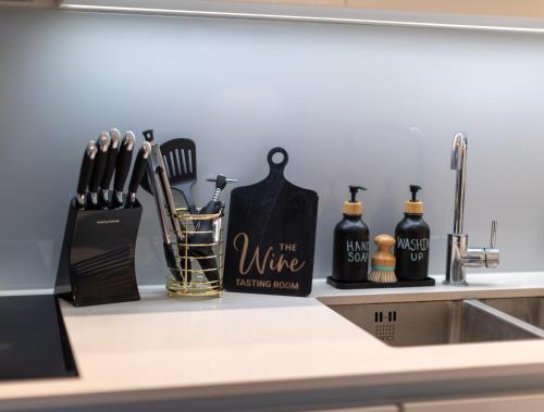 a kitchen counter with knives and utensils on it at Heathrow Haven in Yiewsley