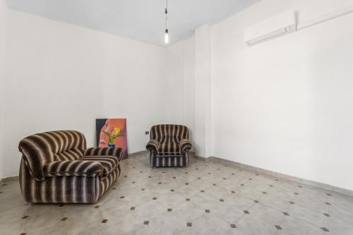 two chairs sitting in a room with white walls at Arbus Aventino Centrale in Arbus