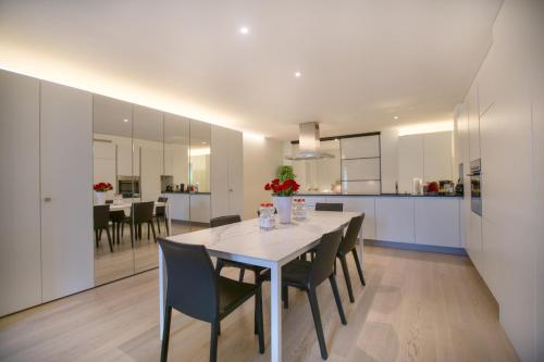 a kitchen and dining room with a white table and chairs at Montreux Lake View Apartments and Spa - Swiss Hotel Apartments in Montreux