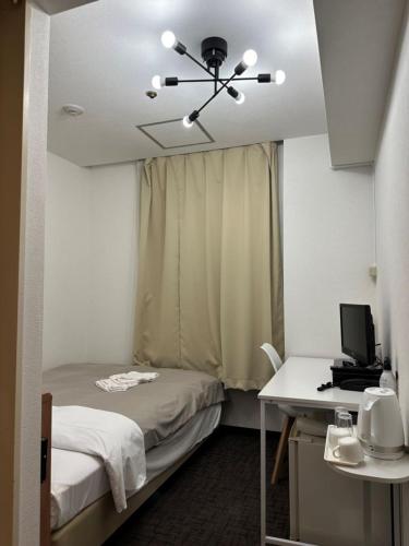 a room with a bed and a desk with a computer at Hotel Royal Oak Gotanda in Tokyo