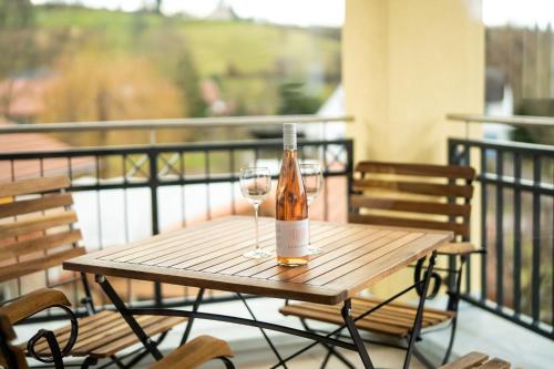 a bottle of wine sitting on a table with two glasses at VILLA BERTA-EuropaPark-Schwarzwald-Freiburg in Ettenheim