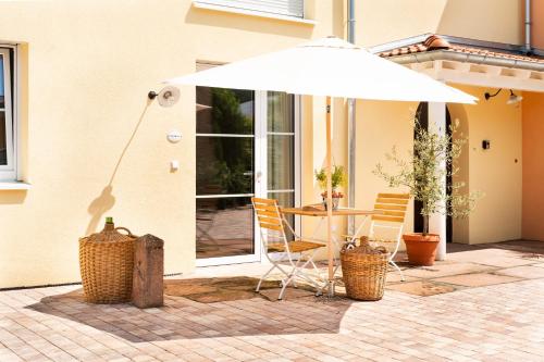 a table and chairs under an umbrella on a patio at VILLA BERTA-EuropaPark-Schwarzwald-Freiburg in Ettenheim