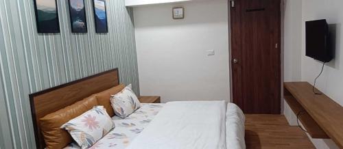 a bedroom with a bed with two pillows on it at Hotel Green Park - Sector 11 in Gandhinagar