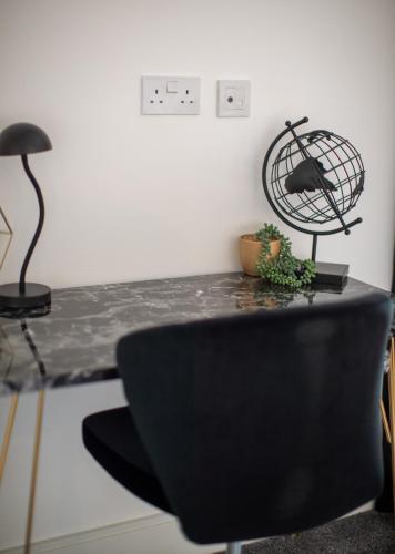 a black chair sitting on a table in a room at Heathrow Haven in Yiewsley