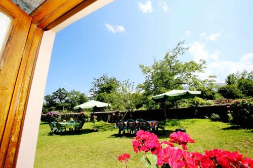 Casa Vacacional El Molinin في Villanueva de Ardisana: حديقة فيها طاولات وكراسي ومظلات