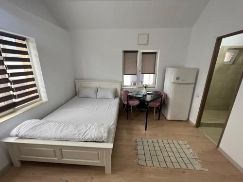a small bedroom with a bed and a table at Compact House in Cluj-Napoca