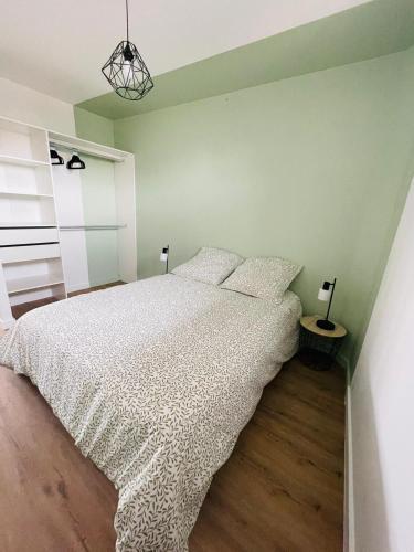 a bedroom with a bed with a white comforter at Verrières 2 in Issoire