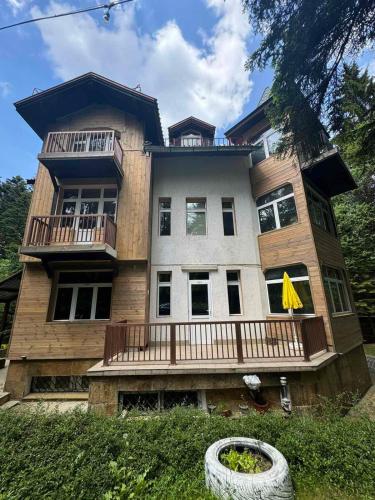 a large wooden house with a porch and balcony at The Forest Villa Borovets by BookVillaBG in Borovets