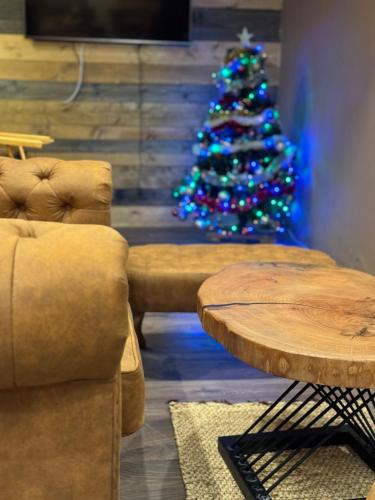 a christmas tree in a living room with a table at The Forest Villa Borovets by BookVillaBG in Borovets