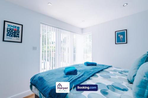 a bedroom with a bed with blue sheets and a window at Spacious Detached Bungalow By Harperletting Short Lets & Serviced Accommodation Buckely With Pool table & Driveway in Buckley